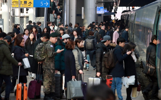 설 연휴를 하루 앞둔 지난 14일 오후 서울역 KTX 승차장에서 귀성객들이 줄지어 열차에 오르고 있다.